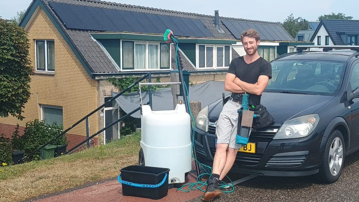 Glazenwasser naast zijn osmosetank en auto